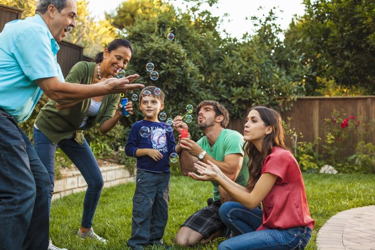 A family enjoying a mosquito-free backyard, highlighting the benefits of professional mosquito control.
