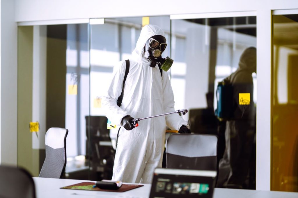 Technician applying pest control treatment in an office setting