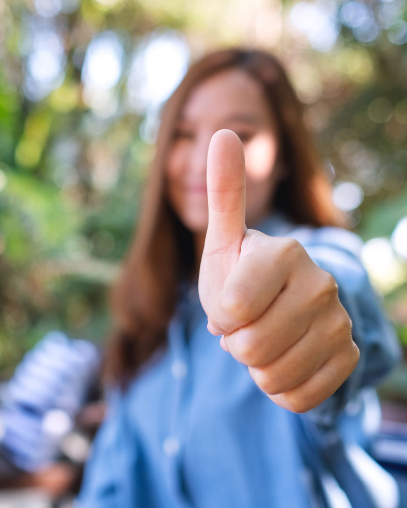 A woman shows a thumbs up gesture, indicating satisfaction with pest service approval. - TruForce Pest and Wildlife - pest control in Knoxville